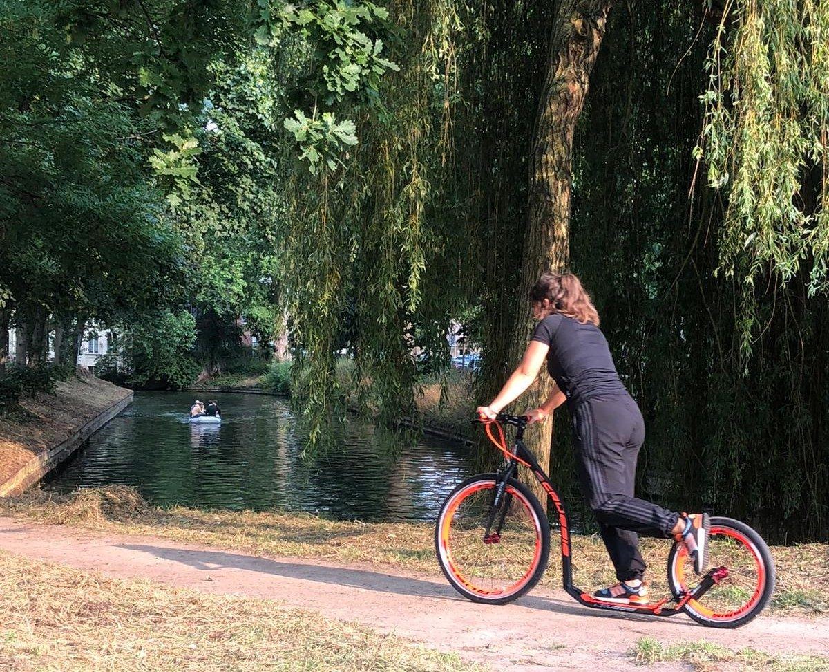 Steppen met een gehuurde kickbike langs het water in een Utrechts park