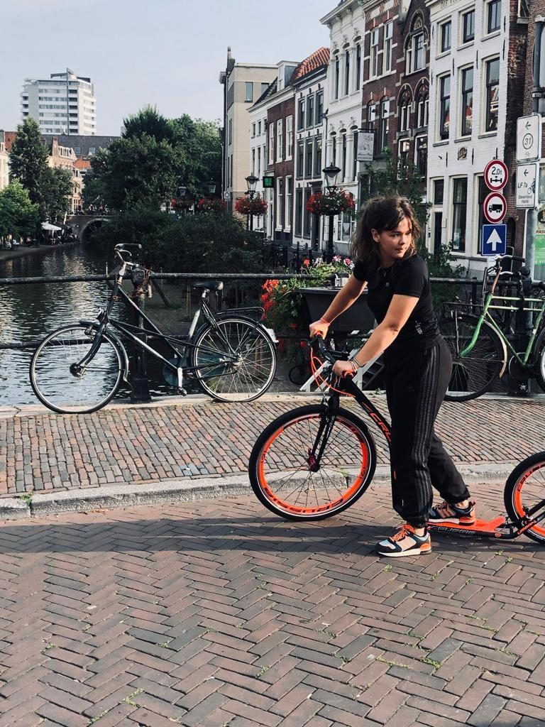 Iemand met een gehuurde step aan de Oudegracht in Utrecht