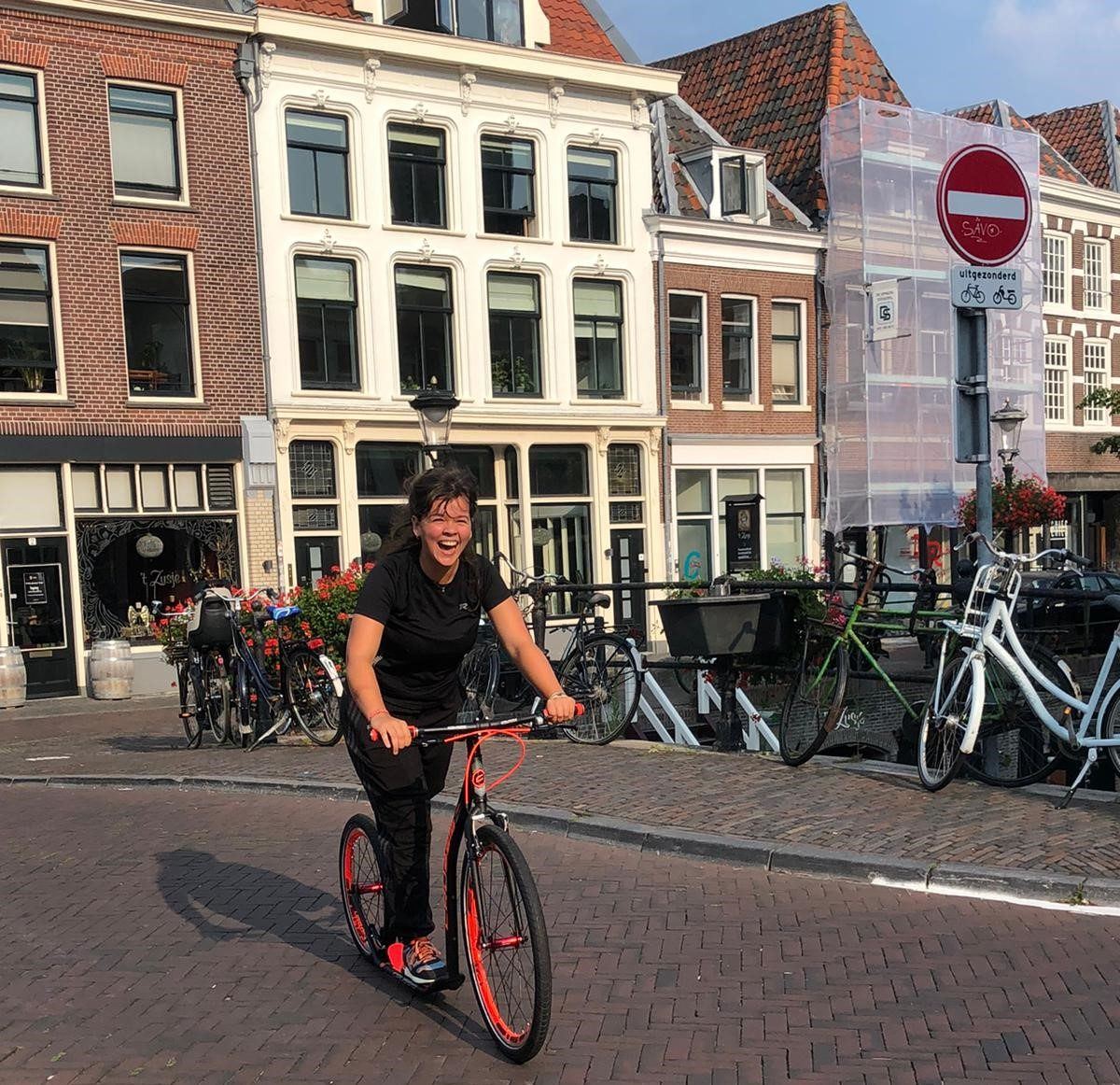Steppen op een kickbike door de binnenstad van Utrecht langs geparkeerde fietsen