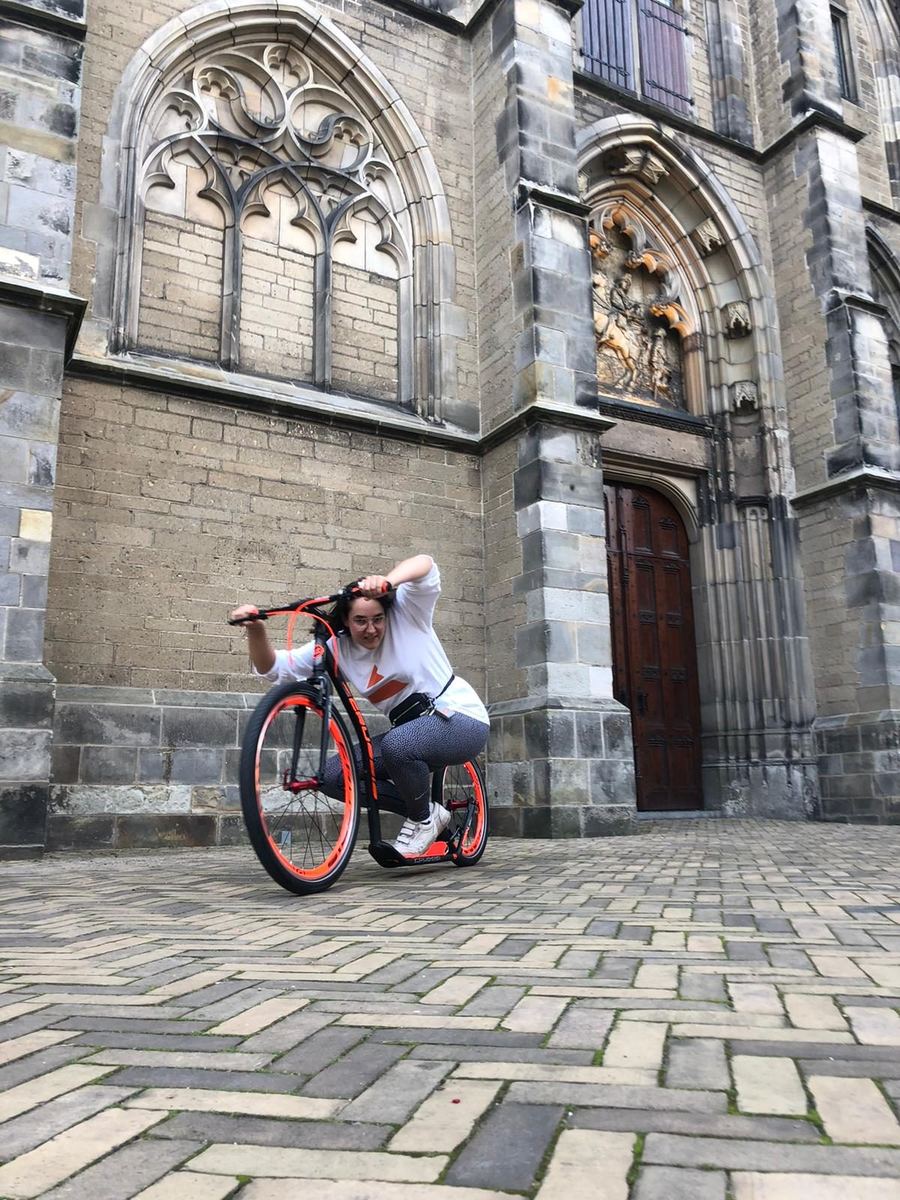 Twee mensen met gehuurde kickbikes voor de Domkerk in Utrecht